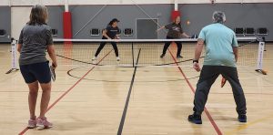 Pickleball player about to smash a volley at the indoor courts at the Yreka YMCA.